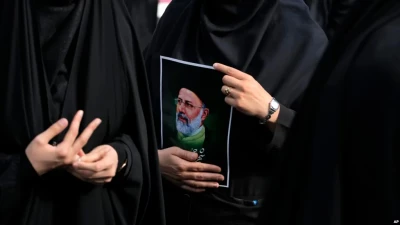 Іранська жінка тримає фотографію президента Ебрагіма Раїсі під час траурної церемонії у Тегерані, 20 травня 2024 року. (Фото: AP Photo/Вахід Салемі)”