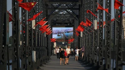 Туристи гуляють "Зламаним мостом" через річку Ялу, що розділяє Північну Корею та Китай. Цей міст розбомбили в 1950 році під час Корейської війни. Залишки конструкції КНДР розібрала, а Китай відновив й перетворив на історичну пам'ятку