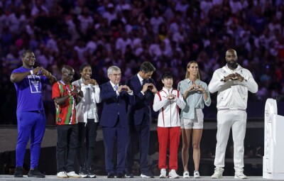 Президент МОК Томас Бах, президент паризьких Олімпійських ігор 2024 Тоні Естанге та спортсмени-представники кожного континенту під час передачі прапора на церемонії закриття Олімпійських ігор у Парижі 2024