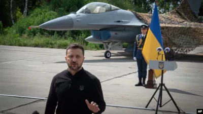 Президент України Володимир Зеленський на тлі винищувачів F-16 у невідомому місці в Україні, неділя, 4 серпня 2024 р. AP Photo/Efrem Lukatsky