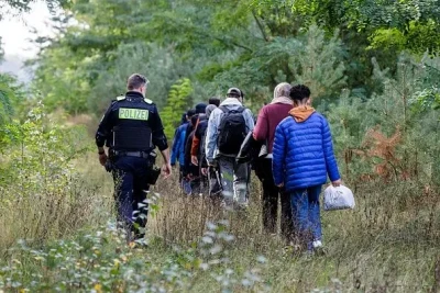 Німецький поліцейський супроводжує нелегальних мігрантів поблизу кордону з Польщею, на якому контроль відновили у 2023 році